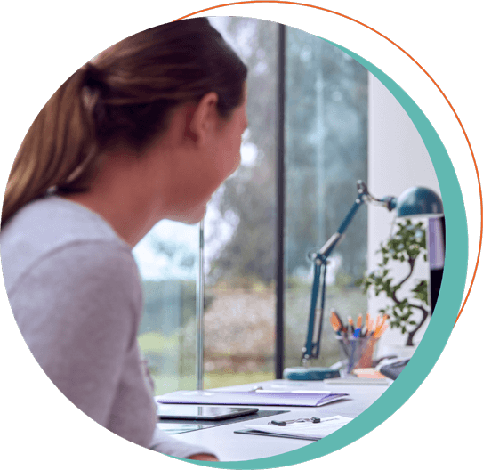 woman sits at a desk, talking with doctor