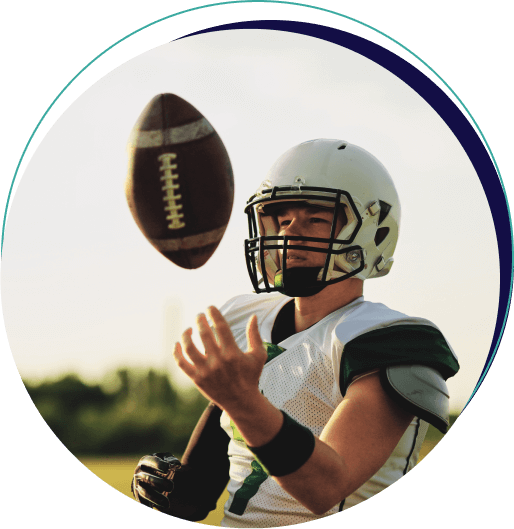 Young football player tosses ball in air