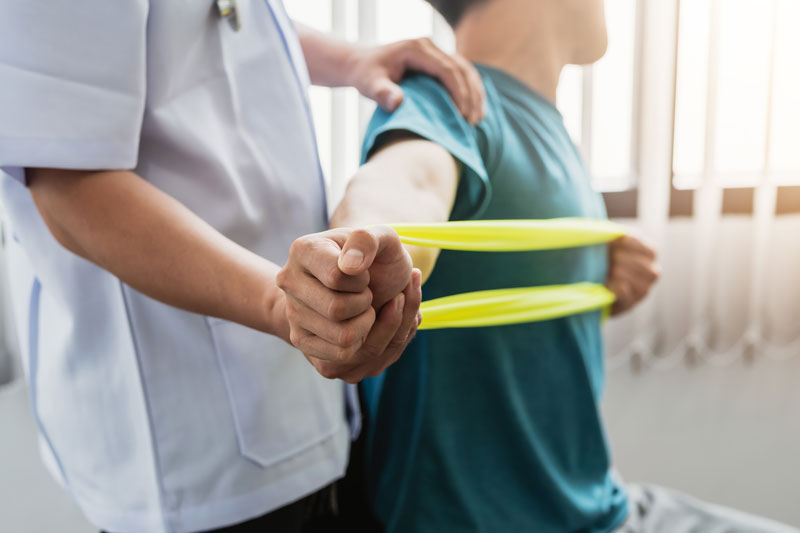 Doctor helps man stretch a band - rehab