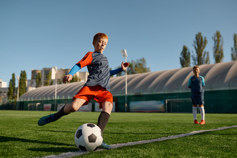 young male soccer player about to kick a ball